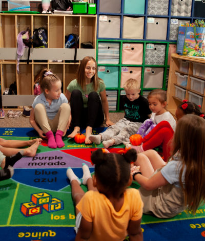 Lexi leading a seated yoga activity with young children